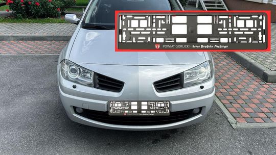 zdjęcie przedstawia samochód na drodze, obok widok ramki do rejestracji w powiecie gorlickim