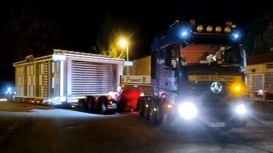 zdjęcie przedstawia ciężarówkę z naczepą stojącą na jezdni w nocy