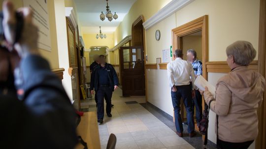 policjanci idący korytarzem w sądzie