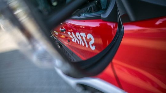 Kolejny pożar w powiecie gorlickim. Strażacy walczą z ogniem w Staszkówce zdjęcie przedstawia lusterko samochodu w którym widać napis straż