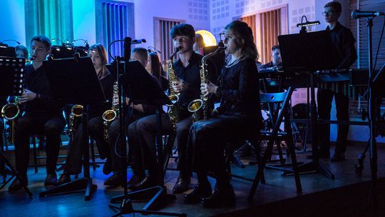 zdjęcie przedstawia młodzież grającą na instrumentach na scenie