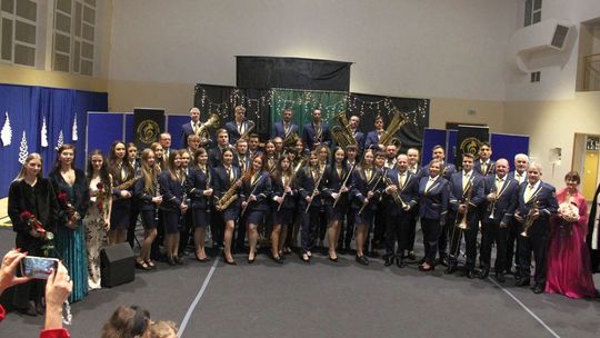 zdjęcie przedstawia dużą grupę osób w mundurach galowych i eleganckich strojach podczas koncertu