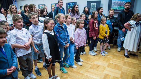 zdjęcie przedstawia grupę dzieci stojących w sali z obrazami