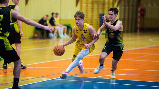 zdjęcie przedstawia dwóch koszykarzy walczących o piłkę