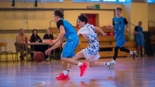 zdjęcie przedstawia dwóch chłopców na boisku walczących o piłkę