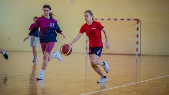 zdjęcie przedstawia dwie dziewczynki grające w koszykówkę