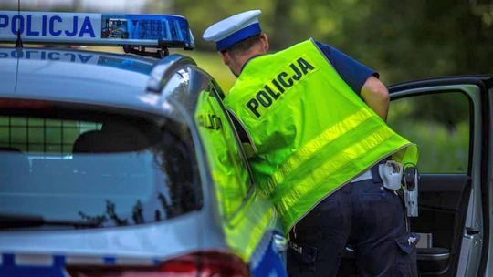 zdjęcie przedstawia policjanta wsiadającego do radiowozu