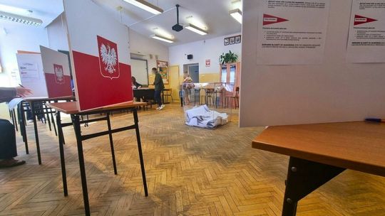 zdjęcie przedstawia lokal wyborczy, na środku urna