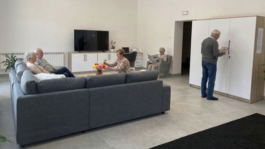 zdjęcie przedstawia wnętrze pokoju z sofą do siedzenia i telewizorem przed nią