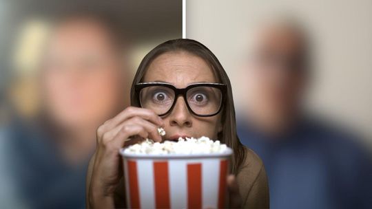 zdjęcie przedstawia kobietę jedzącą popcorn