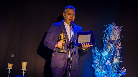 zdjęcie przedstawia mężczyznę ze statuetką Dersława