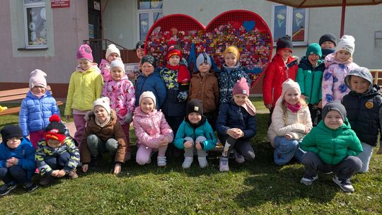 Małe dłonie, wielkie serca – przedszkolaki z Woli Łużańskiej pomagają zdjęcie przedstawia grupę dzieci przed budynkiem szkolno przedszkolnym