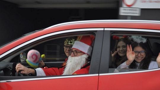 zdjęcie przedstawia samochód w których siedzi dwóch chłopaków, przebranych na mikołaja, z tył dziewczyny przebrane za anioły