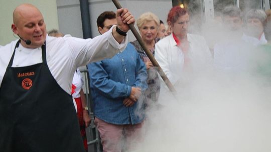 kucharz z chochlą nad wielką patelnią