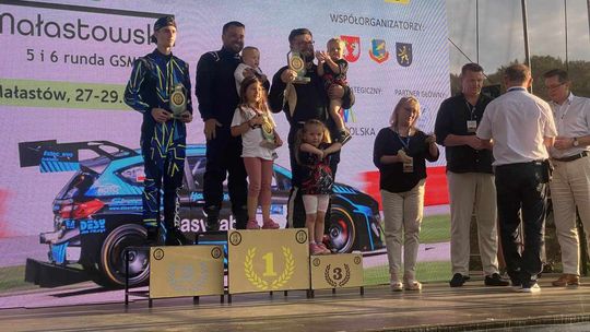 zdjęcie przedstawia mężczyzn na podium z pucharami