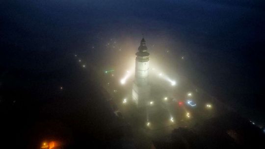 miasto widziane z drona, domy i wieża we mgle