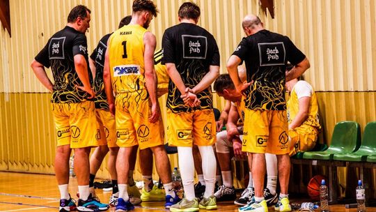 zdjęcie przedstawia kilku mężczyzn w jednolitych koszulkach sportowych stoją obok siebie w kole