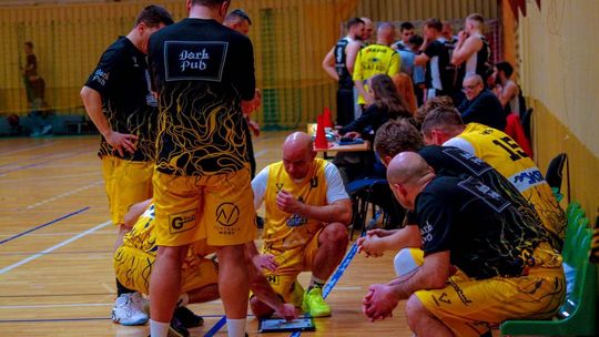 zdjęcie przedstawia kilka osób na hali sportowej, zawodnicy są w koszulkach sportowych