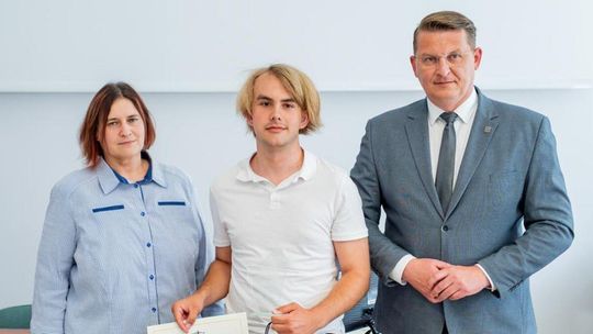 zdjęcie przedstawia laureata konkursu wraz z wice starostą i panią mecenas