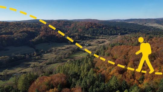 szczyty wzniesień, na zdjęciu grafika żółta przerywana linia i grafika turysty z placakiem