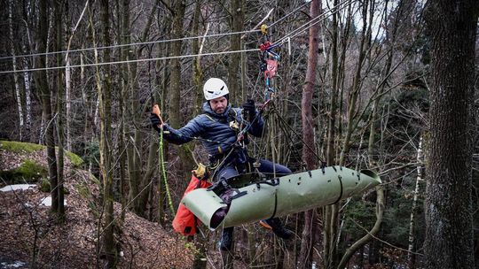 Nasi strażacy pierwsi w Polsce. Brawo! zdjęcie przedstawia osobę w kasku na linie