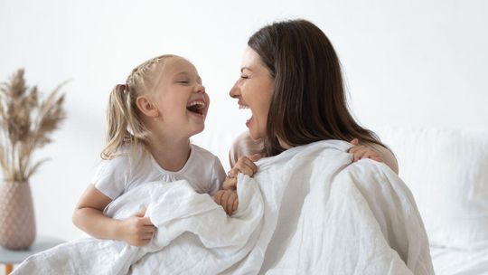 Zdjęcie przedstawia matkę z córką śmiejące się