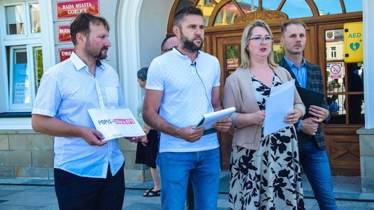 zdjęcie przedstawia kilka osób stojących przed budynkiem