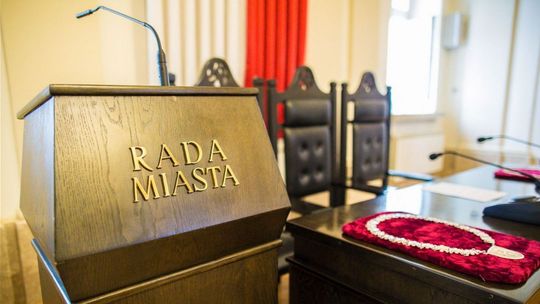 zdjęcie przedstawia mównicę z mikrofonem na której pisze rada miasta