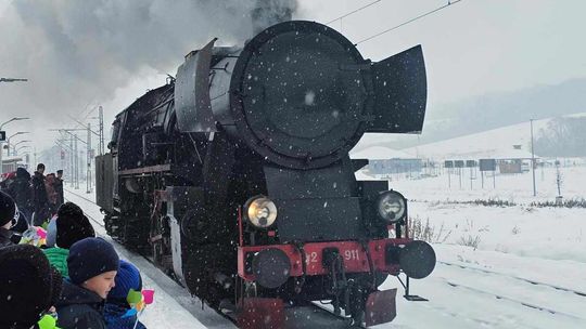 dymiąca stara lokomotywa wjeżdża na peron dworca PKP Bobowa, na peronie stoją dzieci