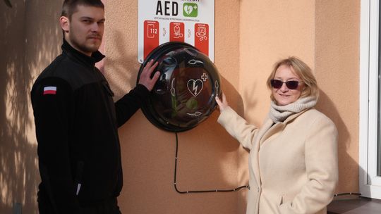 zdjęcie przedstawia kobietę i mężczyznę trzymających ręce na kapsule na ścianie