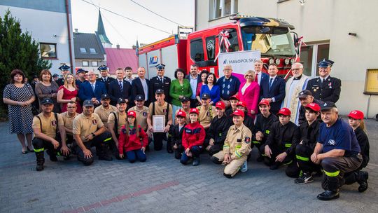 zdjęcie przedstawia grupę osób przed samochodem pożarniczym OSP Bobowa