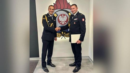 zdjęcie przedstawia dwóch mężczyzn w mundurach podających sobie ręce