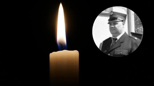 Płomień świecy na czarnym tle i zdjęcie zmarłego strażaka