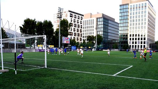 Kadr z meczu piłki nożnej w Gdyni, zawodniczki na boisku, w tle wieżowce