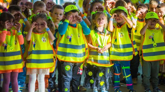 zdjęcie przedstawia dzieci w kamizelkach odblaskowych