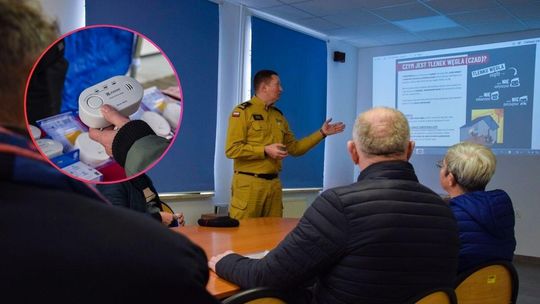 zdjęcie przedstawia ludzi z strażakiem na sali