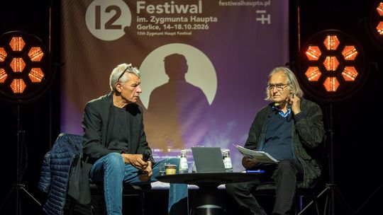 dwóch mężczyzn siedzących przy stolikach
