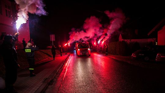 samochody strażackie jadą ulicą wśród rac