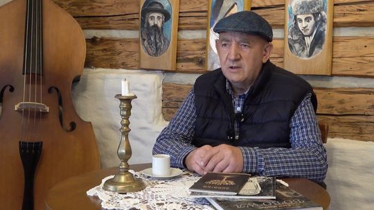 zdjęcie przedstawia mężczyznę siedzącego przy stoliku