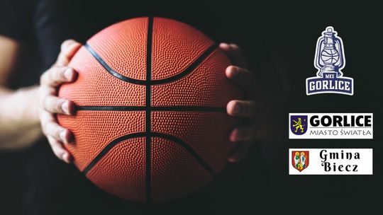 ręce trzymające piłkę do koszykówki, obok logotypy gorlic, biecza i mks gorlice