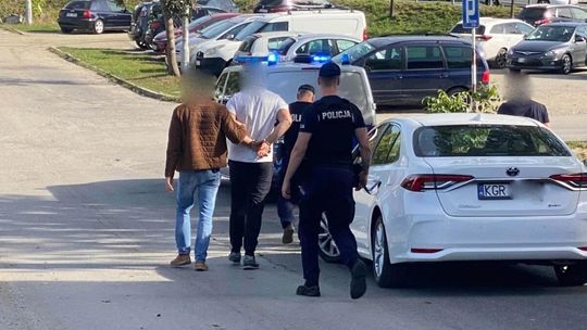 Doprowadzenie mężczyzny do samochodu przez policjantów