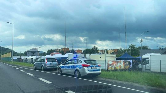 zdjęcie przedstawia policyjny radiowóz i pojazd stojący na poboczu ulicy