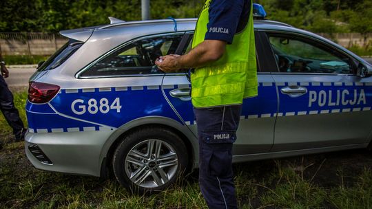 zdjęcie przedstawia policjantów stojących obok radiowozu