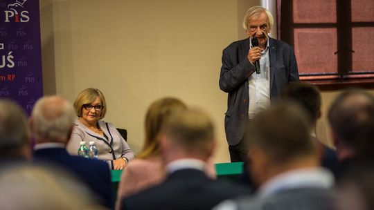 zdjęcie przedstawia kobietę i mężczyznę przed grupą osób