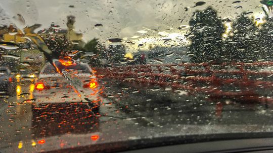 szyba samochodu zalana deszczem rozmyte światła