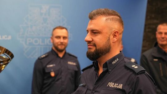 Podkomisarz Sebastian Michalski odbiera puchar