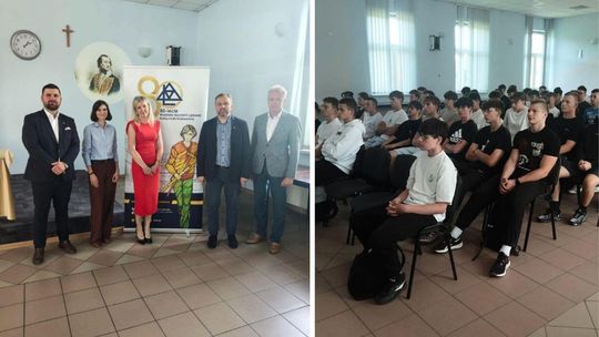 zdjęcie przedstawia kilka osób stojących i siedzących w sali