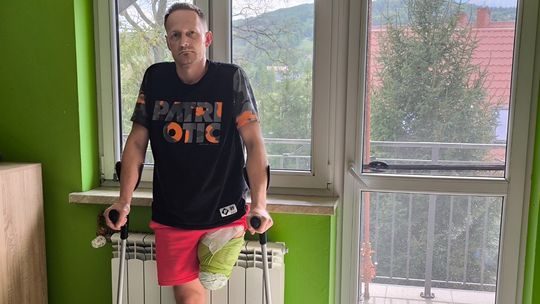 zdjęcie przedstawia mężczyznę podtrzymującego się na kulach