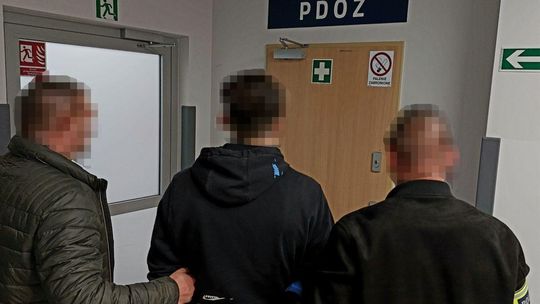 Zdjęcie przedstawia zatrzymanego mężczyznę i dwóch funkcjonariuszy