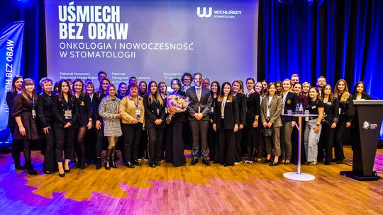 zdjęcie przedstawia grupę osób przed ekranem